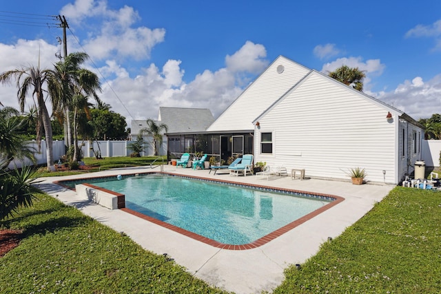 view of swimming pool featuring a sunroom, a patio, and a yard