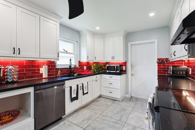 kitchen featuring extractor fan, appliances with stainless steel finishes, backsplash, sink, and white cabinets