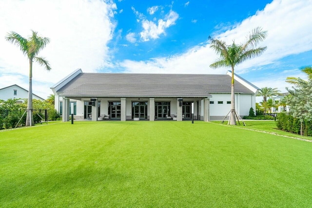 rear view of house featuring a lawn and covered porch