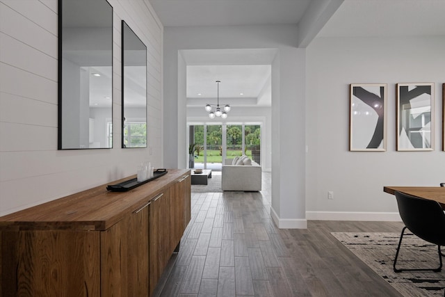 hall featuring dark hardwood / wood-style flooring and a chandelier