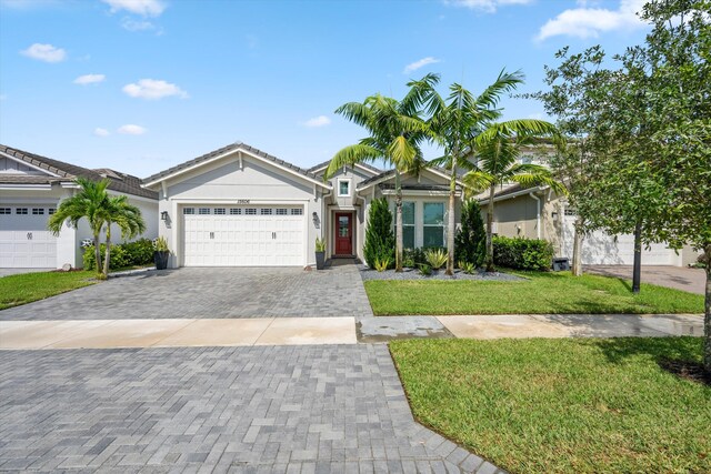 ranch-style house featuring a front lawn and a garage