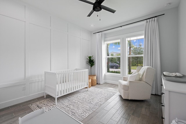 bedroom featuring ceiling fan, a crib, and multiple windows