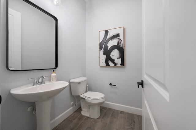 bathroom with hardwood / wood-style flooring and toilet