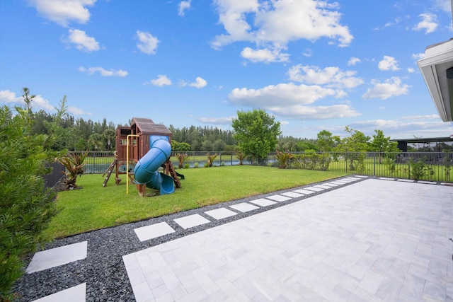 view of playground featuring a lawn and a patio