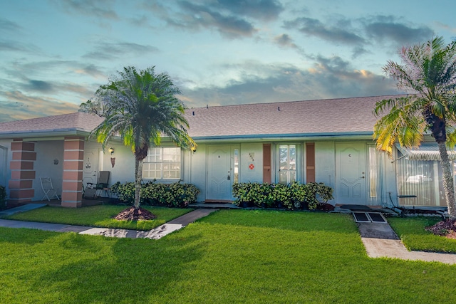 single story home with a lawn