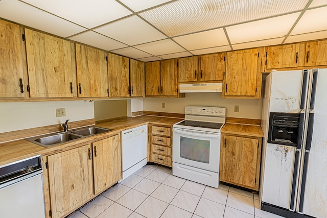 kitchen featuring white appliances, sink, light tile patterned flooring, and a drop ceiling