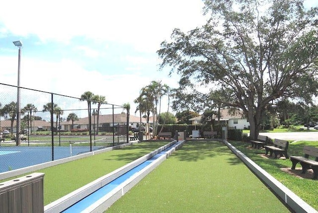 view of home's community featuring tennis court