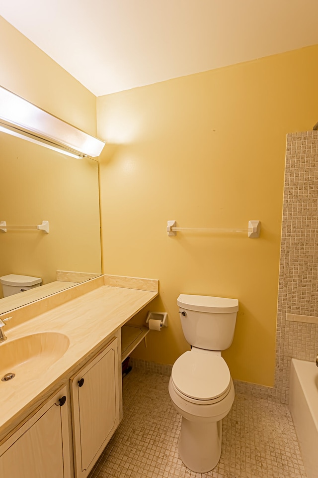 bathroom with tile patterned flooring, vanity, a tub, and toilet