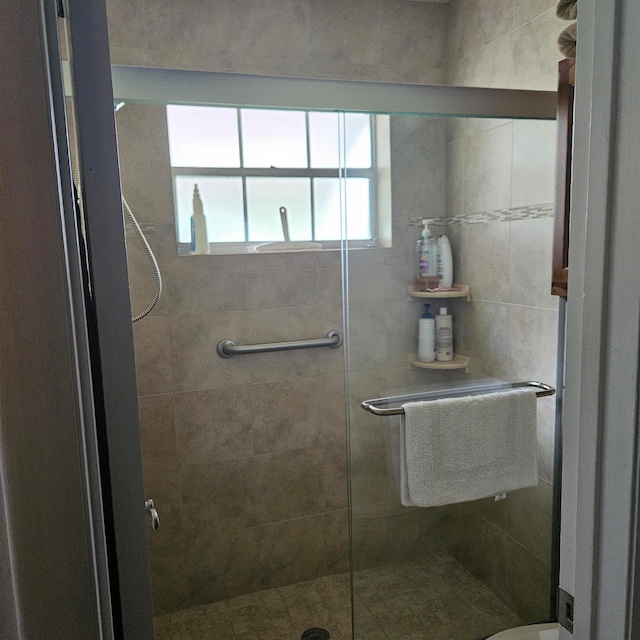 bathroom featuring a shower with door