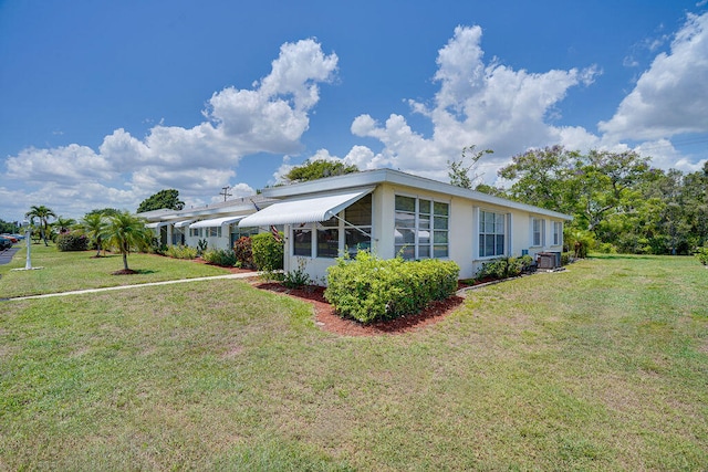 view of front of property with central air condition unit and a front yard