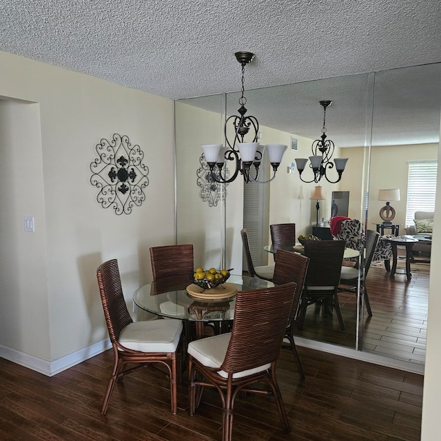 dining room featuring a textured ceiling, dark hardwood / wood-style floors, and a notable chandelier