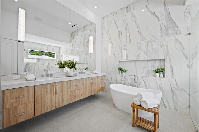 bathroom featuring vanity, a bathtub, and tile walls