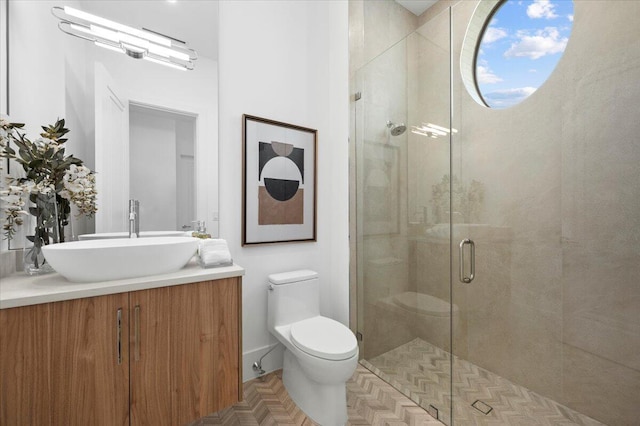 bathroom with vanity, toilet, an enclosed shower, and parquet floors