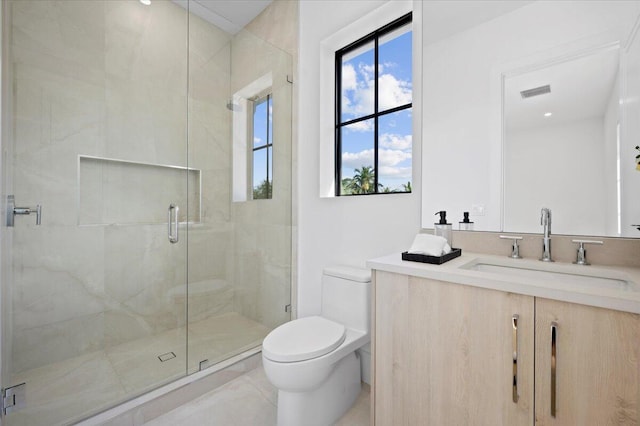 bathroom with a shower with door, vanity, and toilet