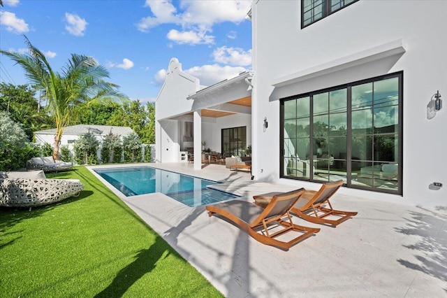 view of swimming pool featuring a patio area and a lawn