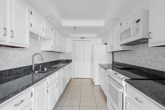 kitchen featuring sink, white cabinets, white appliances, and a raised ceiling