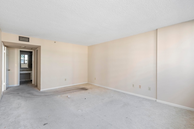 carpeted spare room featuring a textured ceiling