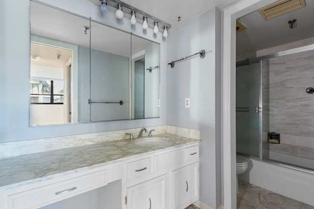 full bathroom with toilet, bath / shower combo with glass door, and vanity