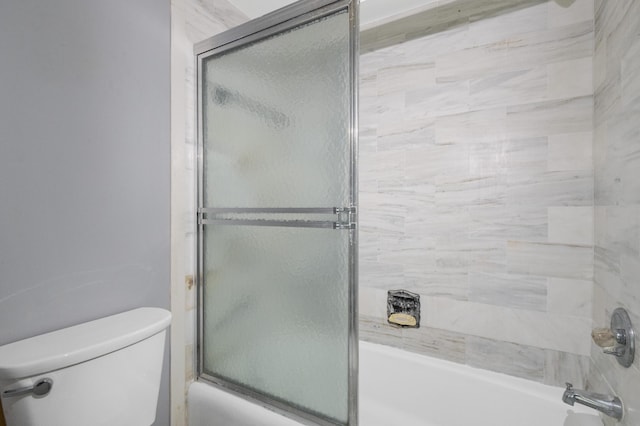 bathroom featuring shower / bath combination with glass door and toilet