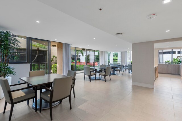 dining room with floor to ceiling windows and light tile patterned floors