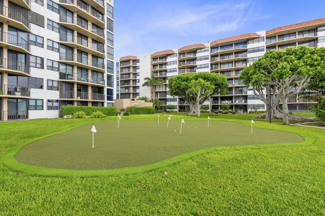 view of home's community featuring a putting area and a lawn