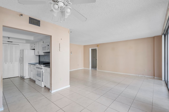 kitchen with light tile patterned floors, white cabinets, a textured ceiling, white appliances, and ceiling fan