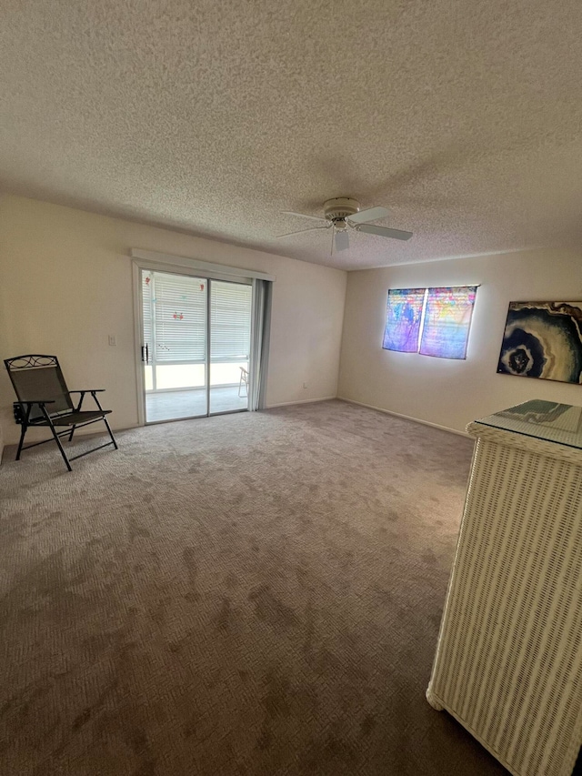 carpeted empty room with a textured ceiling and ceiling fan