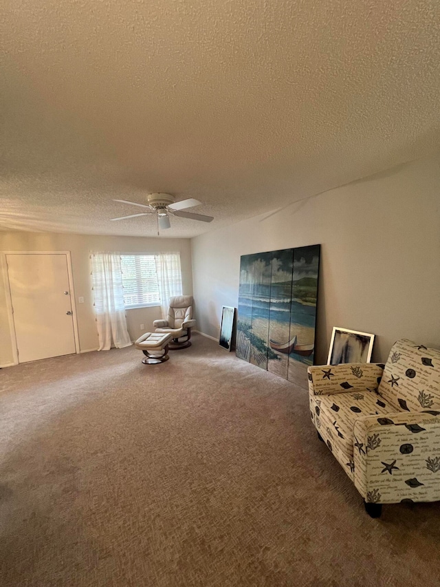 living area featuring carpet flooring, a textured ceiling, and ceiling fan