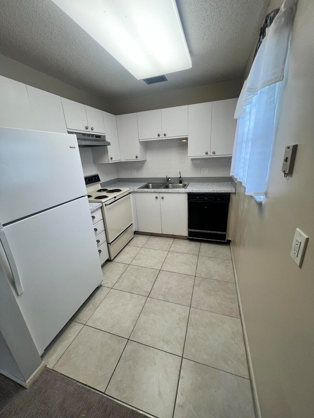 kitchen featuring white appliances, a textured ceiling, sink, light tile patterned floors, and white cabinetry