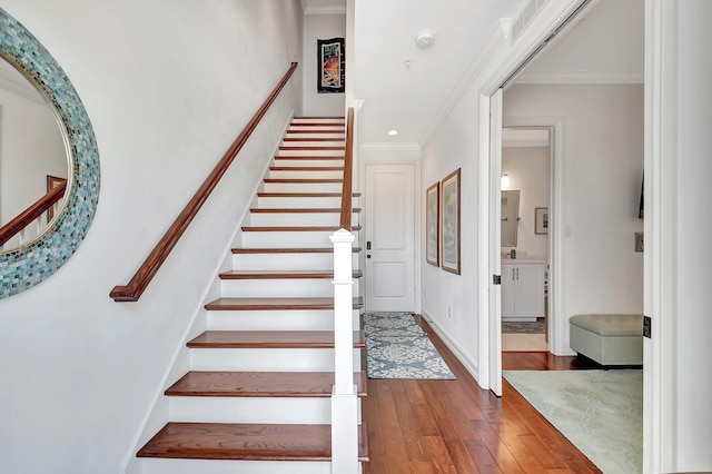 stairs featuring hardwood / wood-style floors and ornamental molding