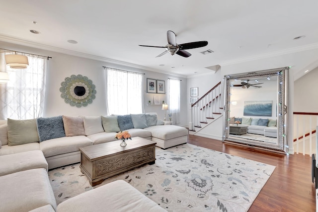 living room featuring ornamental molding, light hardwood / wood-style floors, and a healthy amount of sunlight