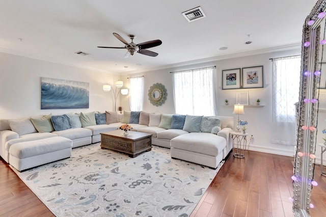 living room featuring hardwood / wood-style floors, ceiling fan, and ornamental molding