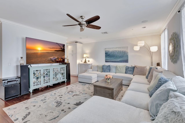 living room with crown molding, ceiling fan, and dark wood-type flooring