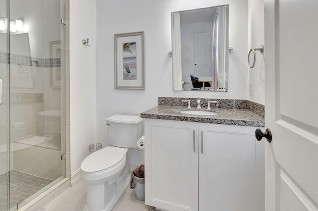 bathroom with tile patterned flooring, vanity, toilet, and an enclosed shower