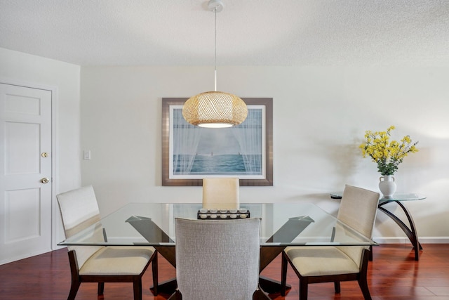 dining area featuring dark hardwood / wood-style floors and a textured ceiling