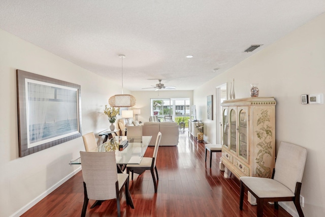 dining room with ceiling fan, a textured ceiling, and dark hardwood / wood-style flooring