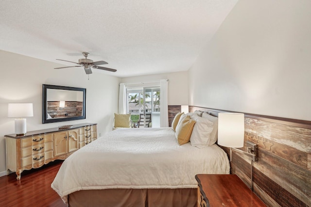 bedroom with dark wood-type flooring, a textured ceiling, and ceiling fan