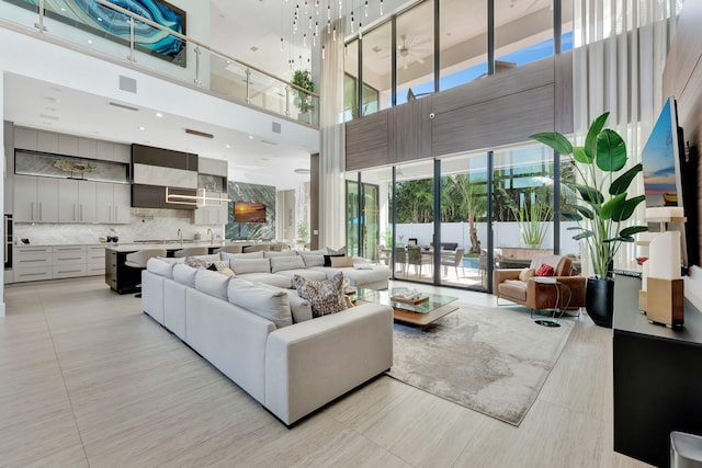 living room with a towering ceiling and light tile patterned floors