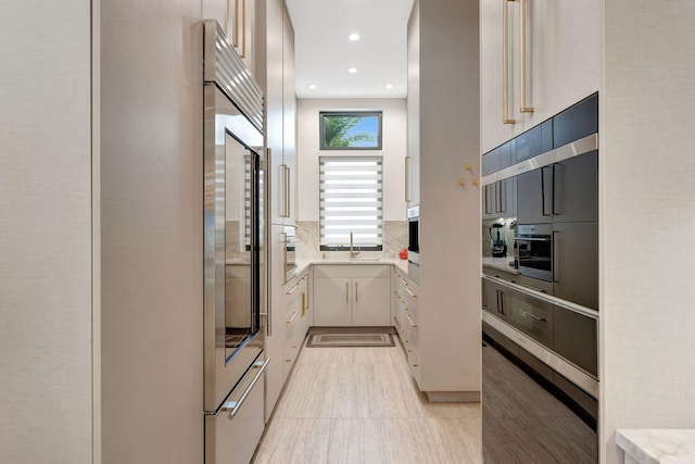 200 NE 6th St, Boca Raton, FL 33432 - kitchen with a sink, recessed lighting, decorative backsplash, light countertops, and built in fridge