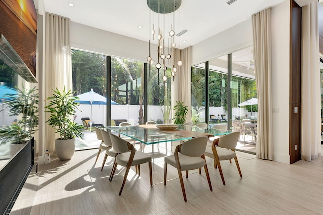 dining space featuring light hardwood / wood-style flooring, a healthy amount of sunlight, and a chandelier