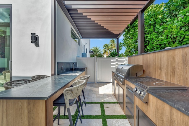 view of patio / terrace featuring a pergola, grilling area, sink, and an outdoor kitchen