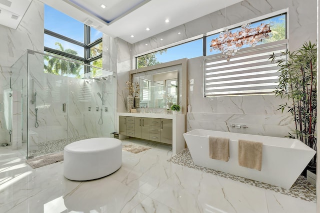 bathroom featuring vanity, tile walls, a wealth of natural light, and plus walk in shower