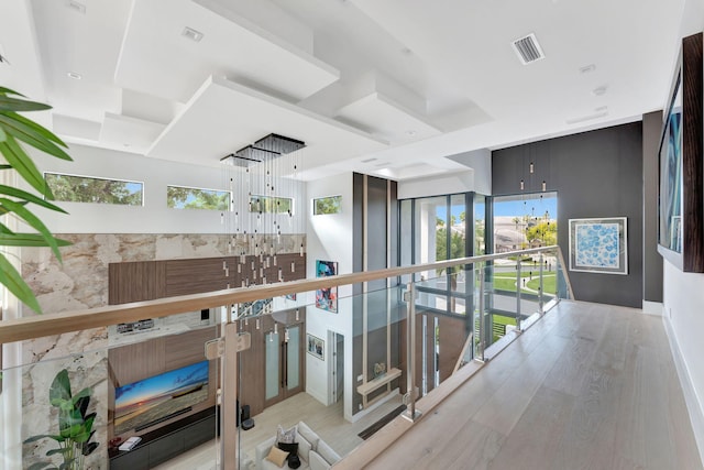 hallway with light hardwood / wood-style floors and a wealth of natural light