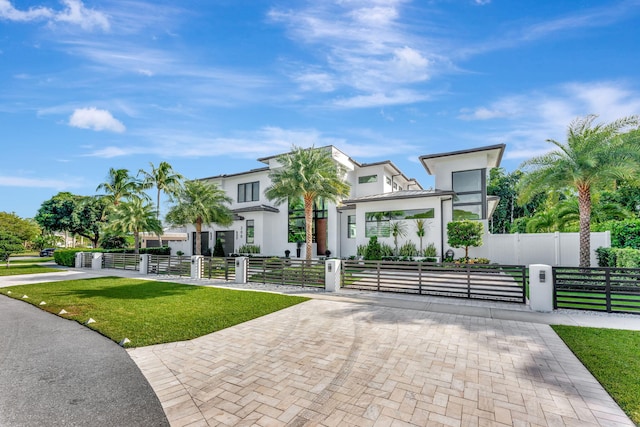 200 NE 6th St, Boca Raton, FL 33432 - contemporary house featuring stucco siding, a fenced front yard, a front lawn, and a gate