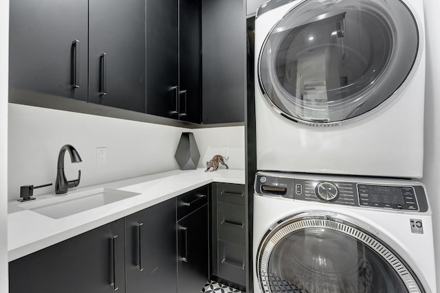 laundry area featuring sink, cabinets, and stacked washing maching and dryer