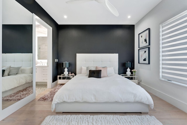 bedroom with connected bathroom, light hardwood / wood-style flooring, and ceiling fan