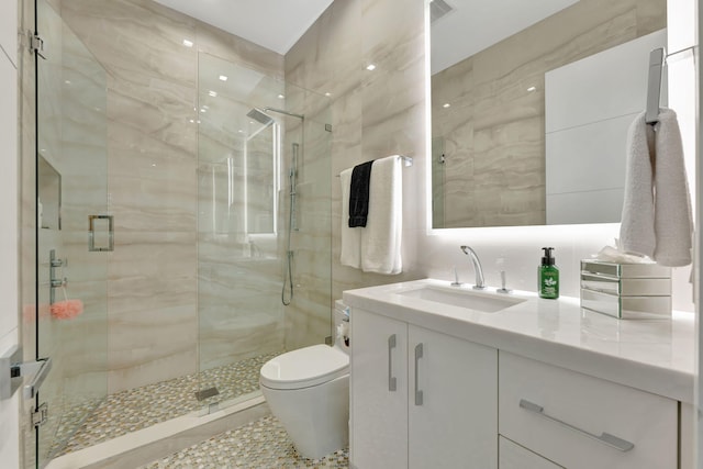 bathroom featuring toilet, an enclosed shower, vanity, and tile patterned flooring