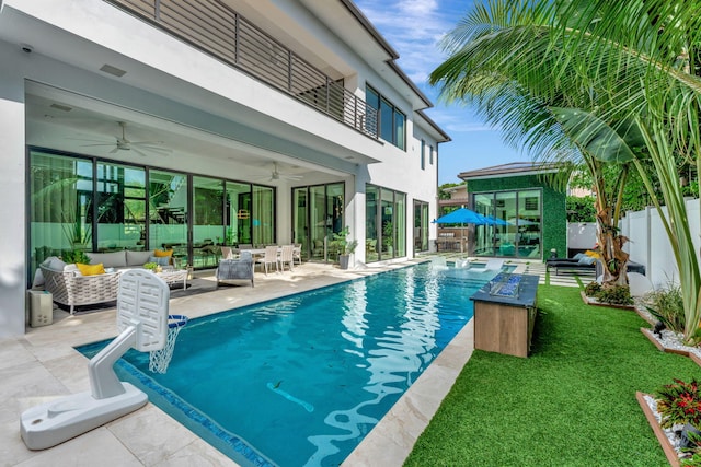 view of pool featuring a patio area, an outdoor living space, a yard, and ceiling fan