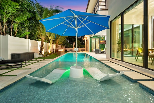 pool at dusk with a patio