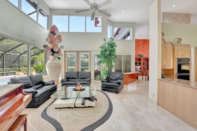 kitchen with a healthy amount of sunlight, light brown cabinetry, black appliances, and light stone counters